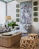 Sisal trunk used as coffee table, wicker stools and decorative tapestry on wall in seating area