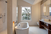 Free-standing bathtub against partition in modern bathroom