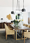Designer lamp above dining table and elegant leather chairs