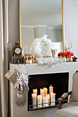Lit candles in festively decorated false fireplace