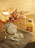 Bathroom accessories on towel and candle lantern scattering warm light
