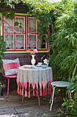 Romantic seating area on terrace outside wooden cabin in garden
