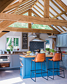 Helle Landhausküche in Blau-Grau mit offener Decke