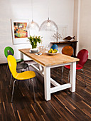 Colourful modern chairs around wooden country-house-style table