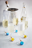 Colourful tags made from corks on glasses of sparkling wine