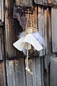 Handmade angel in white dress hung from hinged metal fitting
