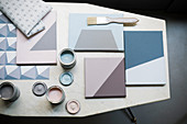 Colour samples on canvases and tins of paint on table