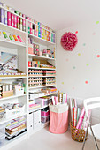 Neatly organised craft supplies on shelves in study