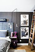 Bed with tall headboard made from reclaimed wood and illustrations on dark wall