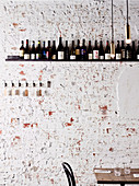 Table in front of rustic stone wall with wine rack (Osteria Ilaria, Melbourne, Australia)