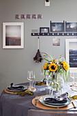 Sunflowers on table set with grey cloth for autumn meal