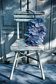 Pine-cone cushion made from grey fabric circles on old chair