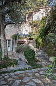 Green garden chair in courtyard of Mediterranean stone house
