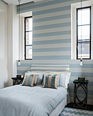 Hellblau und Weiß gestreifte Wand im kleinen Schlafzimmer