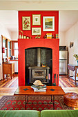 Kaminofen mit roter Wandverkleidung im Wohnzimmer