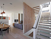 Open-plan staircase in modern architect-designed house with pale wooden elements