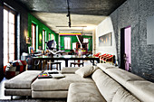 Pale leather couch in renovated loft apartment with black and green walls