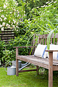 Cushions on garden bench in idyllic summer garden
