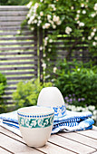Two cups with green and blue patterns on garden table