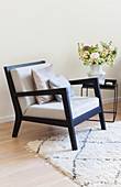 Black armchair with pale upholstery and side table