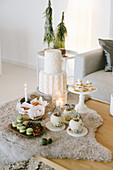 Sweet pastries and Christmas decorations on fur blanket on table