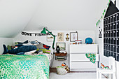 House-shaped calendar on wall in child's bedroom with green accents