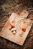 Small modelling clay mushrooms on threads on chopping board