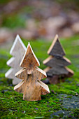 Miniature woodland of wooden Christmas trees on mossy surface