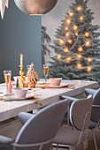 Festively set dining table and wall hanging decorated with fairy lights