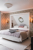 Doppelbett, teilweise in Wandnische, im Schlafzimmer mit Tapete