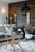Wicker furniture and beige sofa in front of rustic board wall
