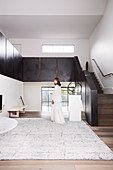 Elegant, minimalist hall with stairs, woman in white dress