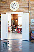 Station clock above open door leading into dining room in wooden house