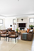 Two leather sofas facing each other and two leather armchairs in living room