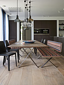 Long dining table with benches and chairs in modern kitchen-dining room