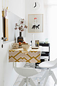 Wall-mounted table with retro tablecloth and bar stools in kitchen