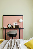 Dressing table against pink panel on green wall in bedroom