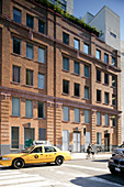 Yellow taxi outside typical American brick façade