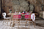 Table set for Christmas with red and white runners in rustic barn
