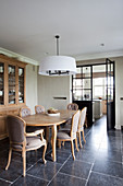 Wooden table, upholstered chairs and dresser in elegant dining room with stone-flagged floor