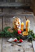 Jar of biscuits and arrangement of candles on rustic wooden surface