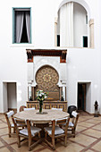 Round table with stone top and chairs in lobby of the Hotel Ryad Dyor (Marrakesh, Morocco)