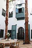 Runder Tisch mit Natursteinplatte und Stühlen in der Lobby im Hotel Ryad Dyor (Marrakesch, Marokko)