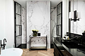 Black marble vanity in luxurious bathroom, wall covered with white marble
