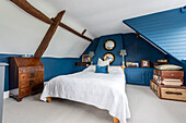 Schlafzimmer mit blauen Wänden unter dem Dach