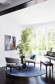 Designer chairs and piano in the music room with lattice door