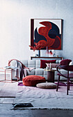 Bequemes Sofa, Bodenkissen, im Hintergrund moderne Kunst über Konsole