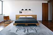 Elegantes Doppelbett und Designerstuhl im Schlafzimmer