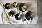 Snacks, feathers and herbs in black bowls and dreamcatcher