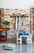 Children's table and chairs in front of brick wall in open living room